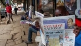 A man reads a newspaper whose front page shows leading presidential candidates for Tuesday's vote, on a street in downtown Nairobi, Kenya, Aug. 6, 2022.