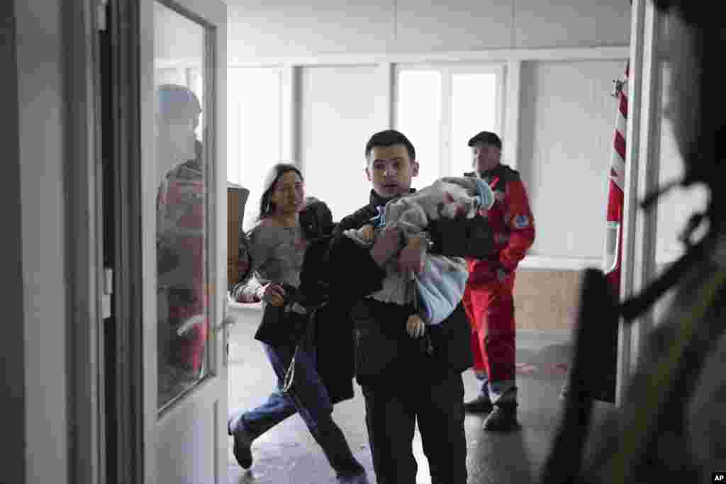 Мариуполь, 4 марта. Марина и Федор, родители 18-месячного раненого Кирилла, вбегают в больницу. Спасти ребенка не удалось (AP)