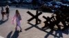 Barricades to prevent Russian troops from invading the city sit along a street as pedestrians walk by in Kyiv, Ukraine, July 28, 2022. 