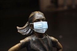 A surgical mask is placed on The "Fearless Girl" statue outside the New York Stock Exchange on Thursday, March 19, 2020, in New York.