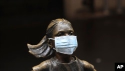 A surgical mask is placed on the "Fearless Girl" statue outside the New York Stock Exchange in New York, March 19, 2020.