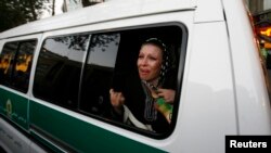 FILE - A woman sitting in a morals police van cries after being arrested in Tehran, June 16, 2008. 
