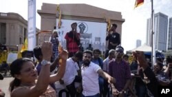 Manifestantes bailan y corean lemas contra el presidente, Gotabaya Rajapaksa, ante su oficina en Colombo, Sri Lanka, miércoles de 13 julio de 2022. (AP Foto/Eranga Jayawardena)