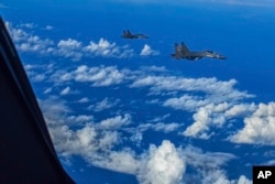 In this photo released by Xinhua News Agency, fighter jets of the Eastern Theater Command of the Chinese People's Liberation Army conduct a joint combat training exercises around the Taiwan Island, Aug. 7, 2022. (Gong Yulong/Xinhua via AP)