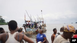 FILE - Fishmongers from Limbe, Cameroon, and neighboring communities wait at the shore for fishing boats to arrive with their catch at the shore on Limbe, Apr. 12, 2022.