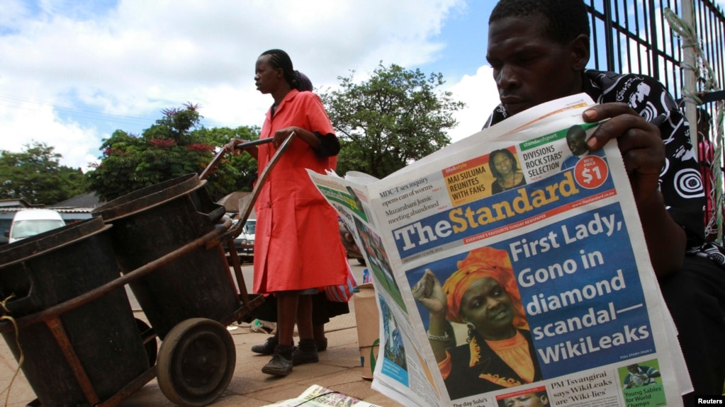 FILE - A man reads a copy of The Standard newspaper on the streets of Harare, Dec. 13, 2010.