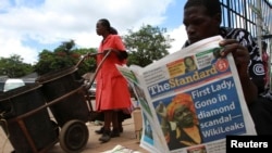 FILE - A man reads a copy of The Standard newspaper on the streets of Harare, Dec. 13, 2010.