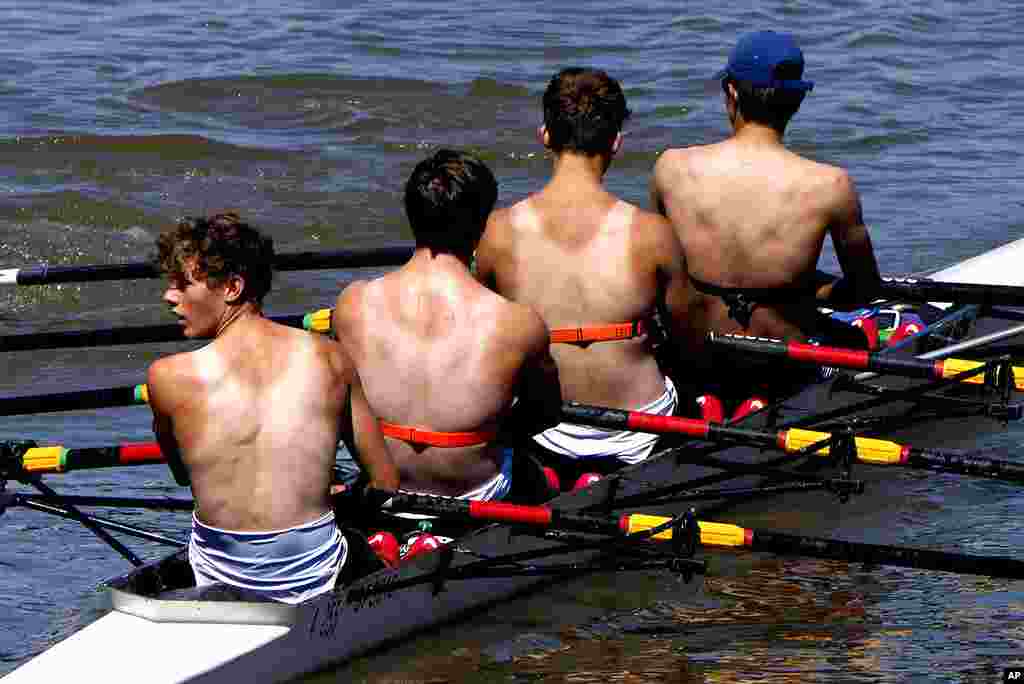 Suntanned rowers work out in the sunny weather on the river Thames near Hammersmith in London, Britain.