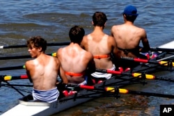 FILE - Partially suntanned rowers work out in the sunny weather on the river Thames near Hammersmith in London.
