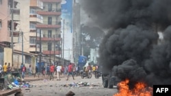 Protesters block roads and hurl rocks in Conakry, Guinea, on July 28, 2022, after authorities prevented supporters of the opposition party, National Front for the Defense of the Constitution (FNDC), from gathering in the streets for a peaceful march. 