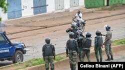 FILE: Guinea anti riot policemen fire teargas as protesters block roads and hurl rocks in Conakry on July 28, 2022, after authorities prevented supporters of the opposition party, National Front for the Defense of the Constitution (FNDC), from demonstrating in the streets.