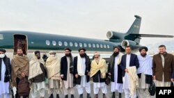 Menteri Luar Negeri Afghanistan Amir Khan Muttaqi (tengah), anggota pejabat senior Taliban Anas Haqqani (kanan) dan anggota delegasi sebelum bertolak ke Oslo, di bandara Kabul, Afhanistan, 22 Januari 2022. (Foto: Afghan Taliban / AFP) 