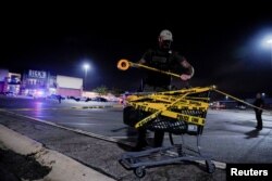 Seorang polisi menempelkan pita kuning di keranjang belanja setelah penembakan di sebuah mal di AS, 17 Juli 2022, sebagai ilustrasi. (Foto: Reuters)