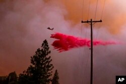 A plane drops retardant while battling the Oak Fire in Mariposa County, Calif., July 22, 2022.