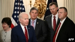 Сенаторы Сьюзен Коллинз и Джо Манчин, конгрессмен Блейк Мур, сенатор Джон Тестер и президент Джо Байден на мероприятии в Белом доме, 7 июня 2022 года.