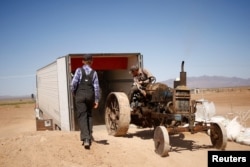 Wilhelm Harder, backs his father's old tractor into a truck as he prepares to leave Chihuahua and move to Campeche state in search of new land to farm, in the Mennonite community of El Sabinal, Chihuahua, Mexico, April 24, 2021. (REUTERS/Jose Luis Gonzalez)