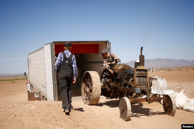 Wilhelm Harder, backs his father's old tractor into a truck as he prepares to leave Chihuahua and move to Campeche state in search of new land to farm, in the Mennonite community of El Sabinal, Chihuahua, Mexico, April 24, 2021. (REUTERS/Jose Luis Gonzalez)