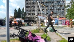 A baby stroller lies by a road after a deadly Russian missile attack in Vinnytsia, Ukraine, July 14, 2022. 