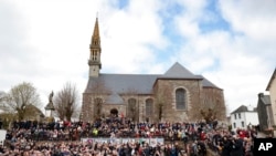 FILE - A crowd watch French President Emmanuel Macron and centrist candidate for reelection arriving in the village of Spezet, Brittany, April 5, 2022.