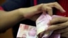 FILE: Seorang karyawan menghitung uang kertas rupiah Indonesia di kantor penukaran mata uang di Jakarta, 23 Oktober 2018. (REUTERS/Beawiharta)