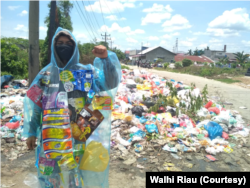 Seorang aktivis menggelar aksi terkait tata kelola sampah kota Pekanbaru yang buruk. (Foto: Walhi Riau)