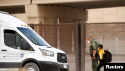Un niño migrante es detenido por un agente de la Patrulla Fronteriza de EEUU después de cruzar el río Bravo para entregarse y solicitar asilo en El Paso, Texas, visto desde Ciudad Juárez, México, el 27 de marzo de 2021.