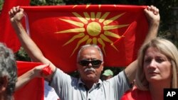 A man holds the old national flag during a protest in front of the parliament building in Skopje, North Macedonia, July 16, 2022. 
