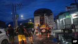 FILE - Men wait to unload a truck near the border with Venezuela, in Cucuta, Colombia, Aug. 5, 2022. The border will reopen after Colombia's new president is sworn-in Aug. 7.