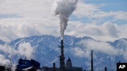 FILE - The Utah State Capitol, rear, is shown behind an oil refinery May 12, 2022, in Salt Lake City.