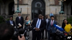 Gambia's attorney general Dawda Jallow, center, and representatives of Rohingya organizations comment outside the International Court of Justice in The Hague, Netherlands, July 22, 2022.