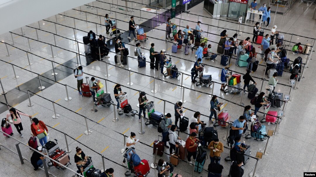 Pelancong mengantre bus antar-jemput ke hotel karantina di Bandara Internasional Hong Kong, di tengah pandemi COVID-19, di Hong Kong, China, 1 Agustus 2022. (Foto: REUTERS/Tyrone Siu)