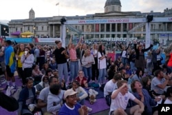 FILE - England supporters celebrate after Beth Mead scored the opening goal as they watch a live screening of the Women's Euro 2022 semifinal soccer match between England and Sweden at the fan area in Trafalgar Square in London, England, July 26, 2022.