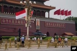 Bendera nasional Indonesia dan China berkibar di dekat potret Mao Zedong di Gerbang Tiananmen di Beijing, Senin, 25 Juli 2022. (Foto: AP)