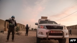 Un policier de l'ONU escorte une voiture blindée de la Mission des Nations unies pour la stabilisation au Mali (MINUSMA), lors d'une patrouille à Tombouctou, le 8 décembre 2021.