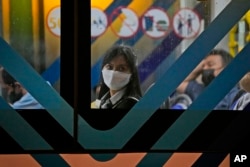 Seorang perempuan mengenakan masker duduk di dalam bus di Jakarta, Selasa, 17 Mei 2022. (Foto: AP)