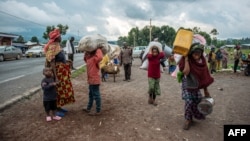 FILE - Internally displaced people from the Kibumba area near the North Kivu city of Goma, arrive on May 25, 2022 at the Kunyaruchinya school trying to shelter from the ongoing clashes between the Congolese Army and the M23 rebels.