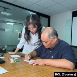 曾遭中国监禁的台湾籍人权工作者李明哲与妻子李净瑜在位于台北的国际特赦组织写信声援人权受害者。(美国之音记者金谷摄)