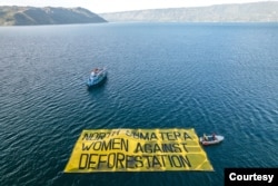 Sejumlah aktivis perempuan melakukan kampanye terkait perlindungan hak masyarakat adat dan menolak deforestasi di kawasan Danau Toba, Sumatra Utara. Rabu 20 Juli 2022. (Courtesy: Greenpeace Indonesia)
