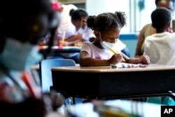 Laiah Collins, 4, center, works on artworks during a class at Chalmers Elementary school in Chicago, Wednesday, July 13, 2022. (AP Photo/Nam Y. Huh)