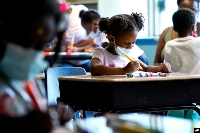 Laiah Collins, 4, center, works on artworks during a class at Chalmers Elementary school in Chicago, Wednesday, July 13, 2022. (AP Photo/Nam Y. Huh)