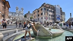 A young woman refills her bottle with water from the Fontana della Barcaccia at Piazza di Spagna in Rome, July 19, 2022, amid a fierce heatwave sweeping Europe.
