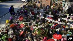 Seorang pria tampak berlutut di depan monumen peringatan korban penembakan di Sekolah Dasar Robb, di Uvalde, Texas, pada 2 Juni 2022. (Foto: AP/Eric Gay, File)