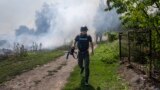 An AFP journalist runs as smoke rises behind after a bombardment in Bakhmut, Eastern Ukraine, July 31, 2022.