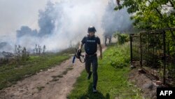 Medijski djelatnik trči usred granatiranja u Bahmutu, u istočnoj Ukrajini, u srpnju 2022.
