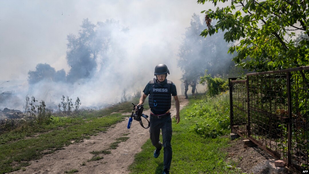 Novinar AFP-a trči dok se dim diže iza njega poslije bombardovanja Bahmuta, istočna Ukrajina, 3. jul 2022. (Foto: AFP/Bulent Kilic)