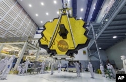 In this April 13, 2017 photo provided by NASA, technicians lift the mirror of the James Webb Space Telescope using a crane at the Goddard Space Flight Center in Greenbelt, Md. (Laura Betz/NASA via AP, File)