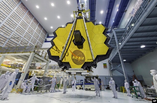 In this April 13, 2017 photo provided by NASA, technicians lift the mirror of the James Webb Space Telescope using a crane at the Goddard Space Flight Center in Greenbelt, Md. (Laura Betz/NASA via AP, File)