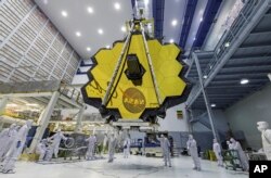 In this April 13, 2017 photo provided by NASA, technicians lift the mirror of the James Webb Space Telescope using a crane at the Goddard Space Flight Center in Greenbelt, Md. (Laura Betz/NASA via AP, File)