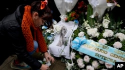 Seorang peziarah meletakkan barang di makam mendiang ibu negara Argentina, María Eva Duarte de Perón, lebih dikenal sebagai Evita, di Buenos Aires, Argentina, Selasa, 26 Juli 2022. (AP/Natacha Pisarenko)