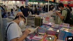 Visitors read at a booth during the annual book fair in Hong Kong, July 20, 2022. 